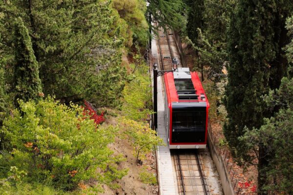 A scenic train winding through Andrews Valley, showcasing lush landscapes and majestic mountains.