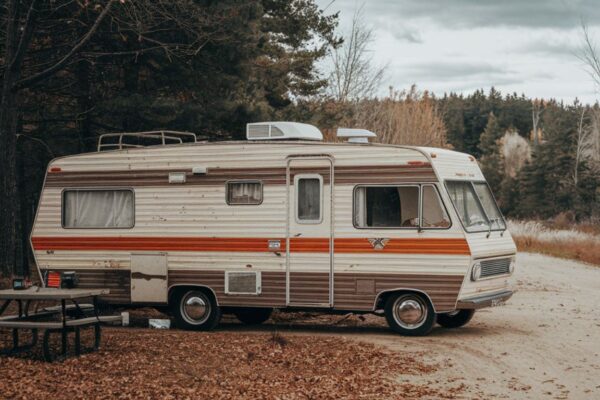 A serene RV parked near a lush forest under a clear sky, representing the essence of jablw.rv.